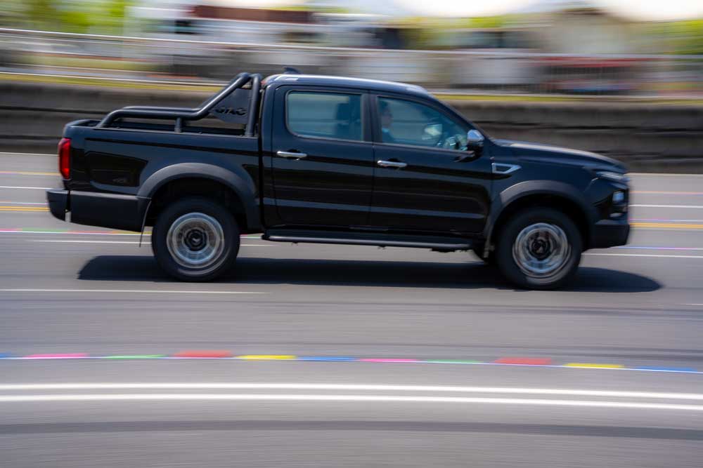 Anhui Province, China – 17042023: South African spec right hand drive JAC T9 pickup truck being driven on a track during a test drive.